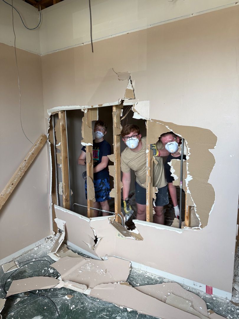 Mission volunteers removing drywall during a renovation project